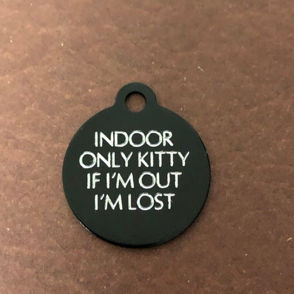 Small black circle tag that says: Indoor only kitty If I'm out I'm lost. All engraved in capital letters.